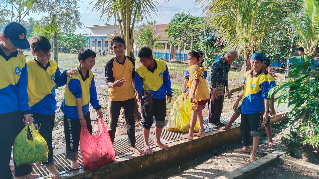 Membersihkan lingkungan di kawasan sekolah